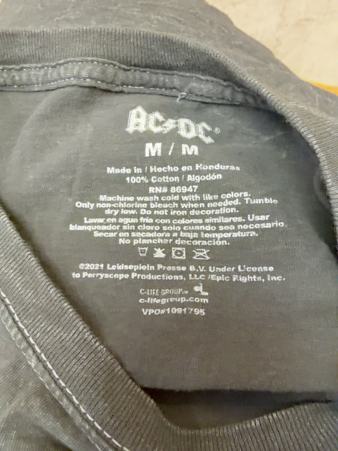 AC/DC tee label showing size medium and 100 percent cotton